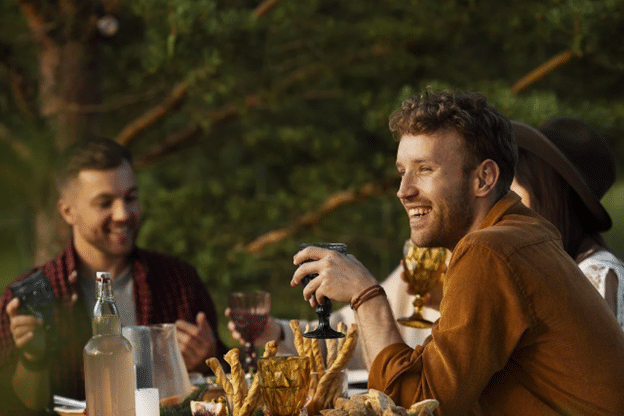 Family and friends gathering at the table at an outdoor wedding - EventLavs.com