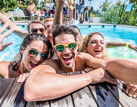 A group of friends celebrating summer in a backyard pool