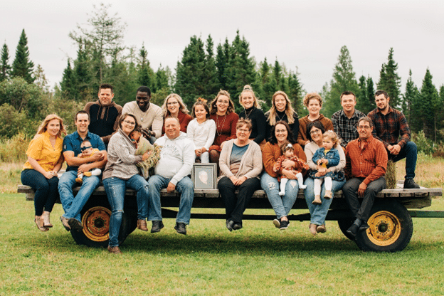 Multigenerational family gathered outdoors on a wagon.