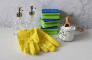 Eco-friendly restroom cleaning supplies—gloves, refillable soap dispensers, sponges, and deodorizing powder.