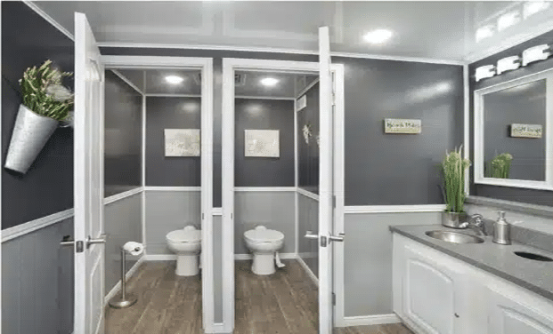 Interior of a luxury restroom trailer with private stalls and modern finishes.